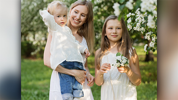 mother and daughters outside with flowers