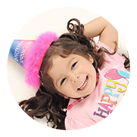 child in birthday party hat button