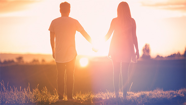couple holding hands in sunset